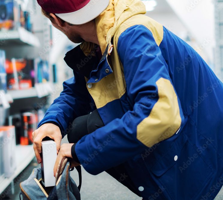 A man shoplifting, in need of a Utah retail theft lawyer.